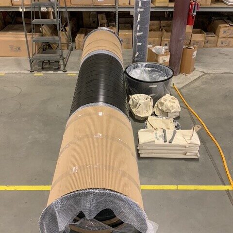 Wrapped spiral duct material staged in a warehouse