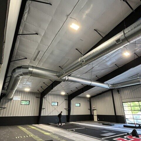 Spiral ductwork with elbow connection and registers in a commercial gym