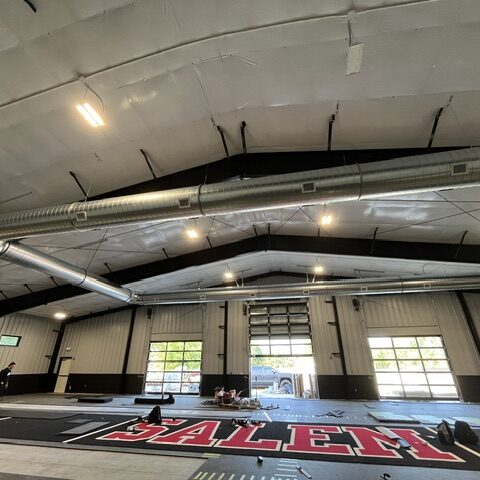 Exposed round ductwork installed above an indoor athletic floor