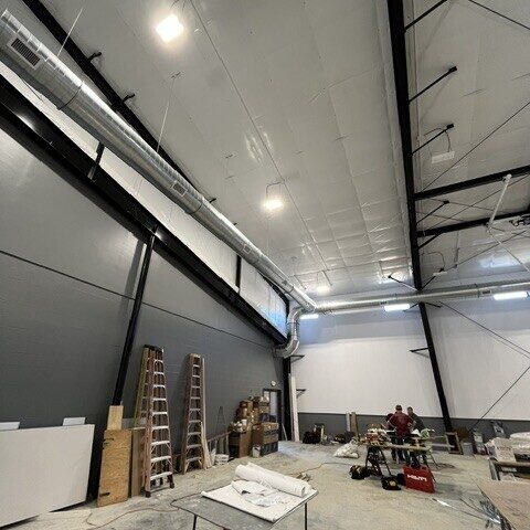 Galvanized spiral ductwork installed near the roofline of a commercial building